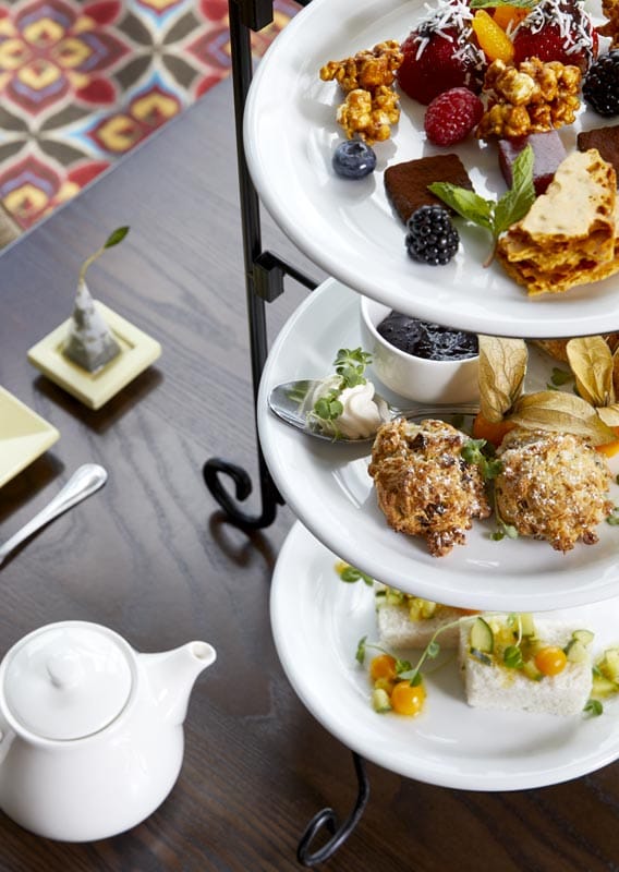 Tea served with a selection of deserts on a trio of stacked plates