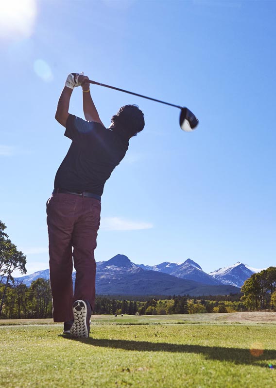 Man swinging golf club at East Glacier