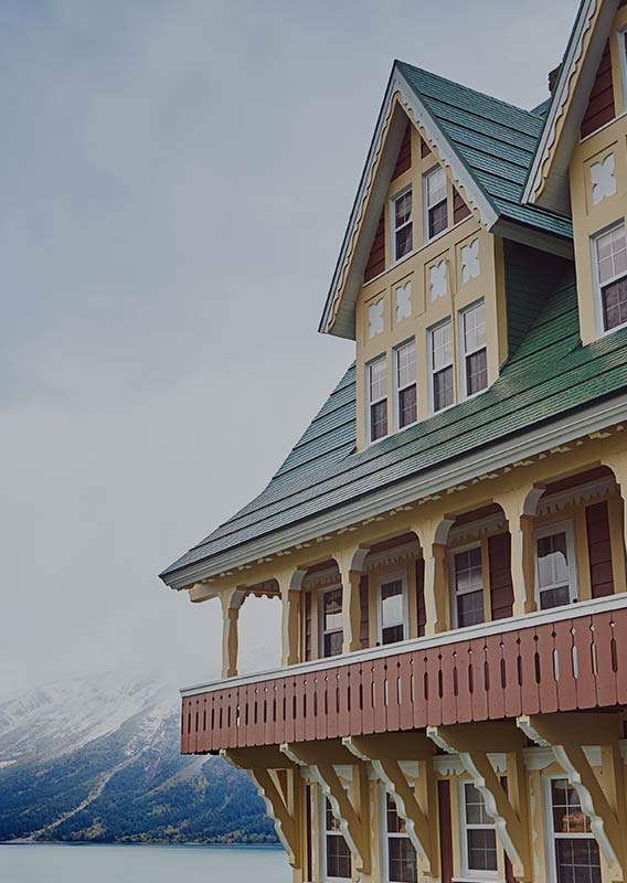 Colorful exterior of Prince of Wale's Hotel balcony, with the lake and mountains in the background