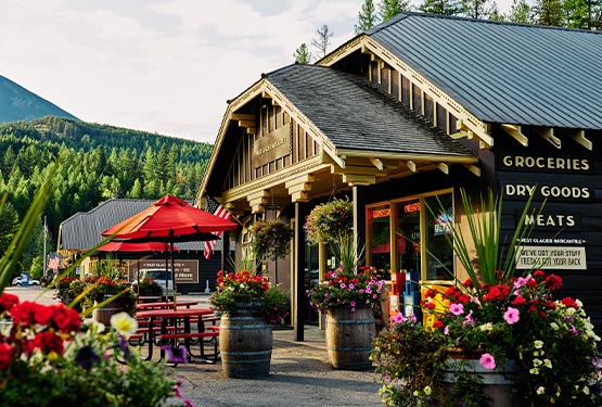 A wooden building with flowerpots all around.