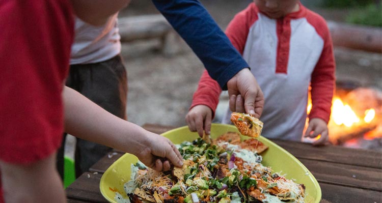 A family starts eating a plate of nachos.