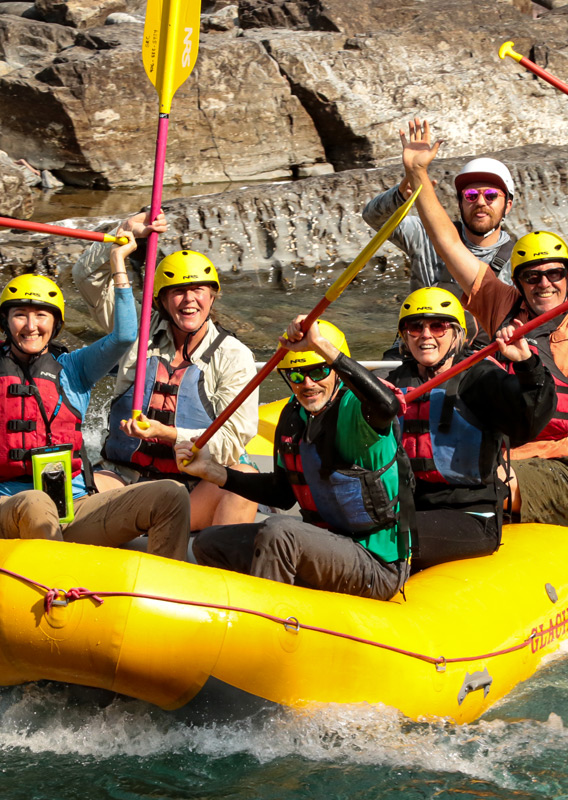 A rafting group cheering while they travel through river rapids
