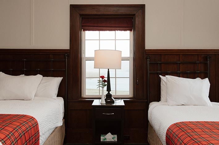 Two hotel beds and a side table between them.