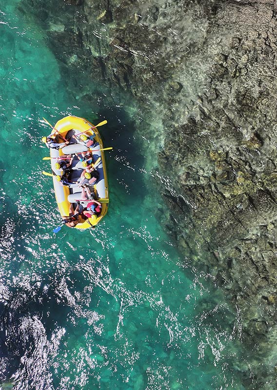 Aerial view of a yellow raft floating over clear water.