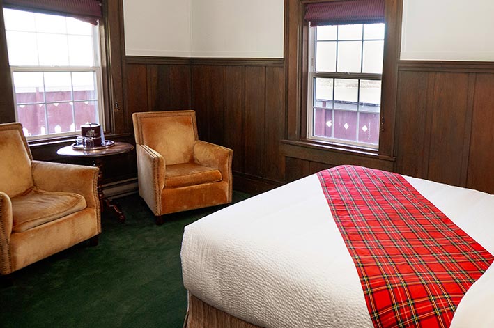 Well-appointed hotel room with one twin and one double bed and mountain views