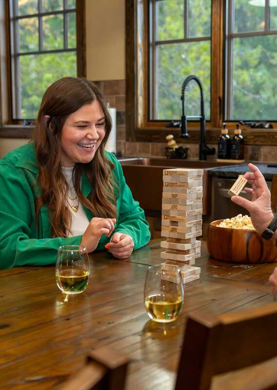 Two people play board games at a big table.