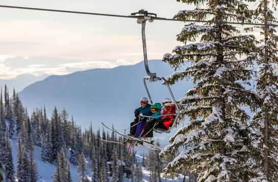 Two people on skis go down a snowy hill 