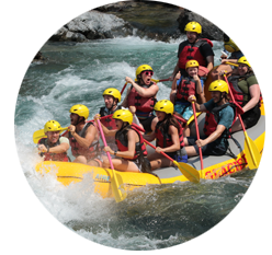 A rafting group paddling down whitewater rapids on the Flathead River.