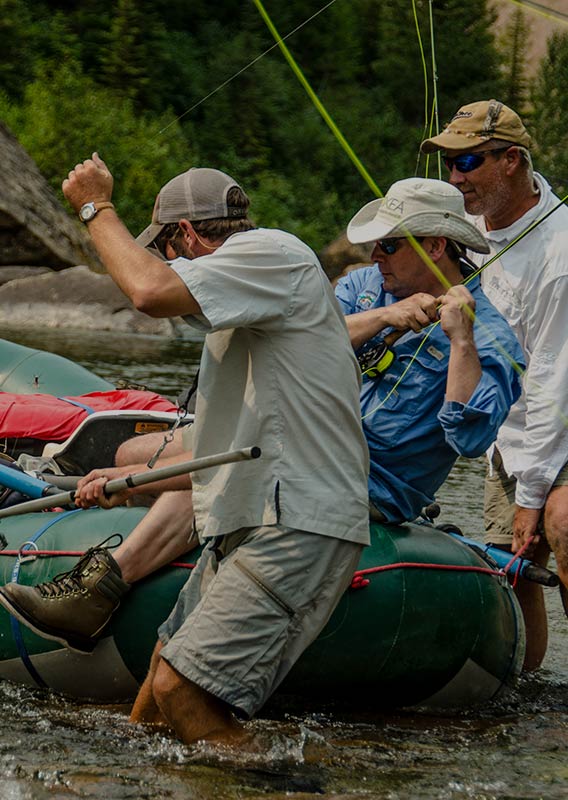 Three men pull on a fishing line.