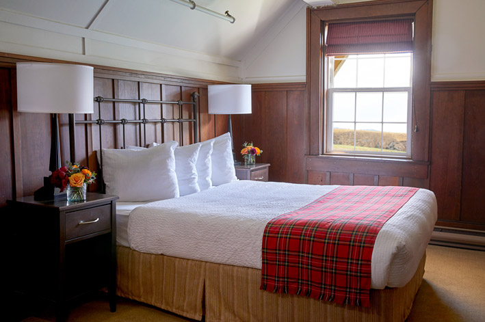 Well-appointed hotel room with one twin and one double bed and mountain views