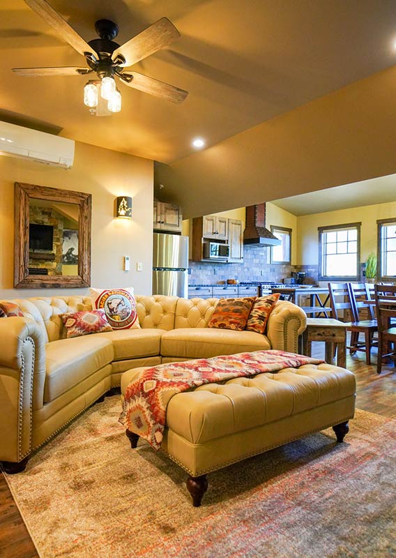 The interior of a suite with a large sofa and a dining area.