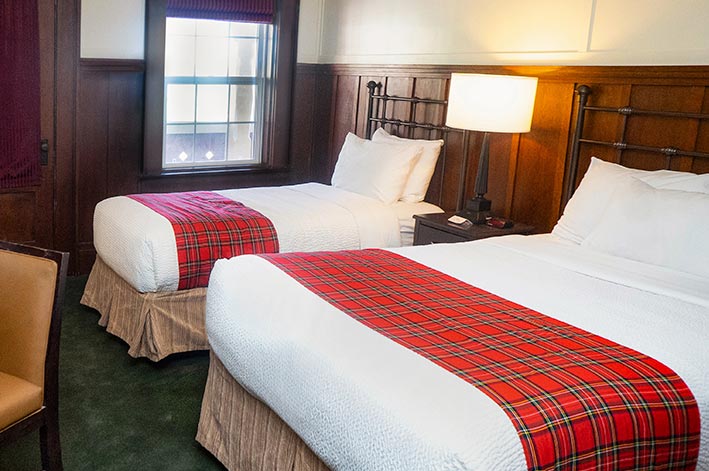 Well-appointed hotel room with one twin and one double bed and mountain views